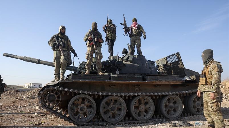 Miliziani ribelli siriani ritratti su un carro armato russo abbandonato nella periferia di Hama