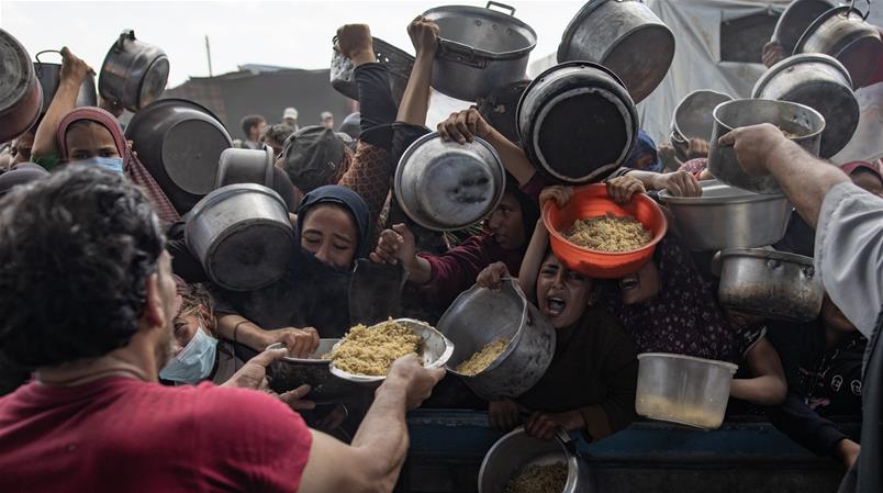 Menschen in der Stadt Chan Yunis im Süden des Gazastreifens stehen für Essen an.