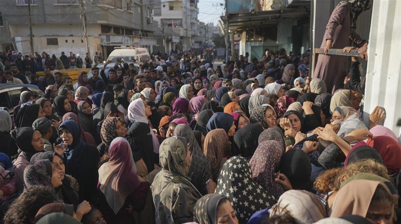 Menschen in Gaza warten vor einer Essensabgabestelle.